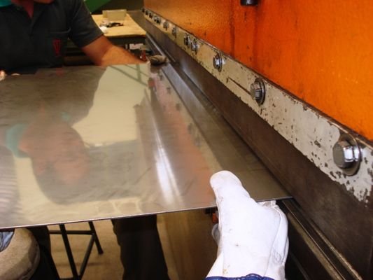 Operador conformando chapa na dobradeira